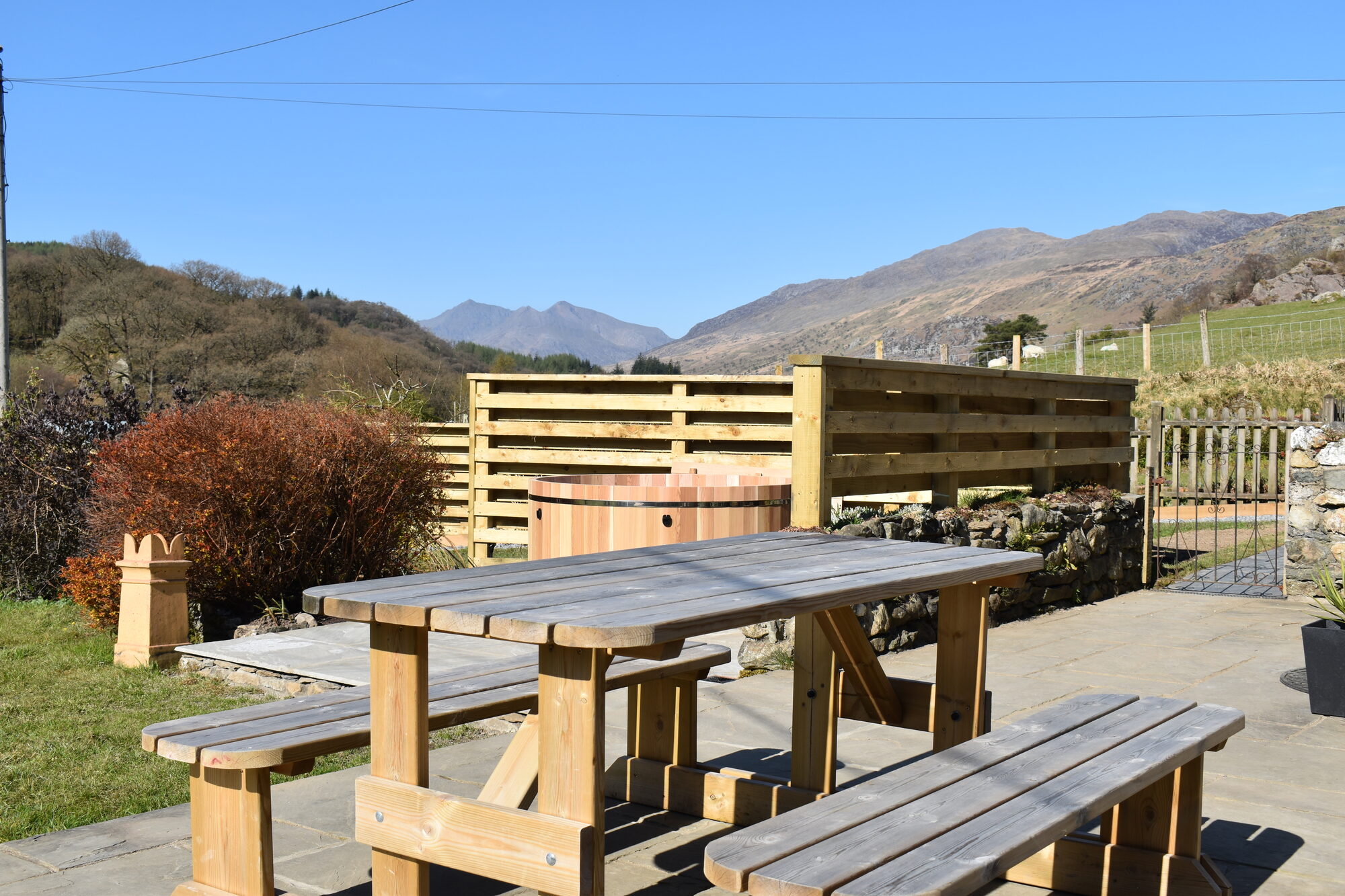 Picnic bench and hot tub in front of Yr Wyddfa