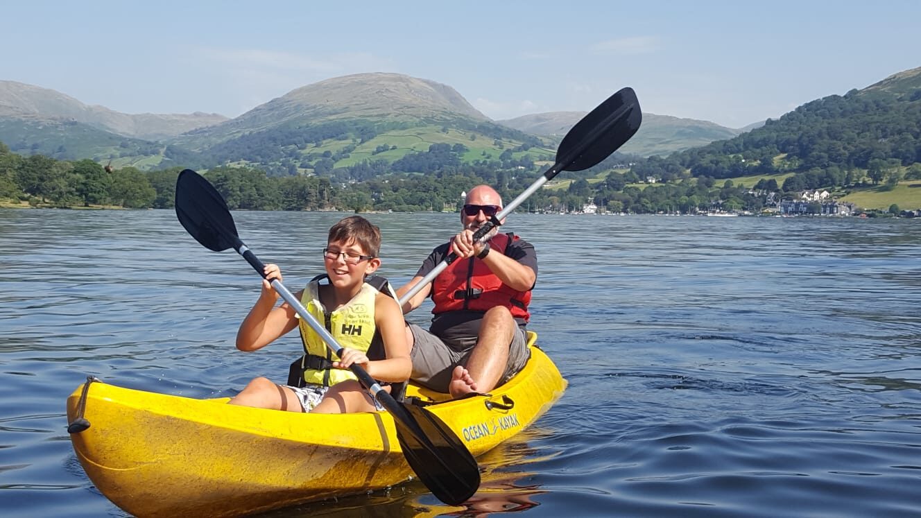 Man and boy kayaking on llynau mymbyr