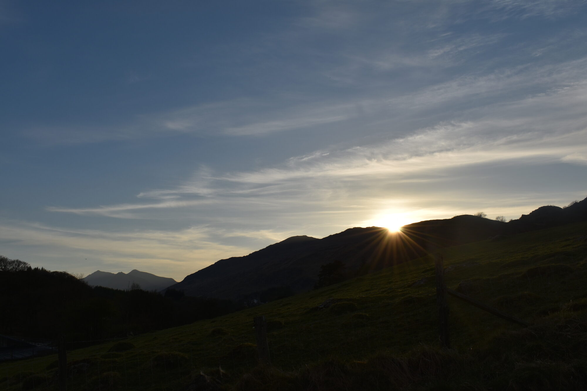 Sunset behind hills with Snowdon massif in the distance