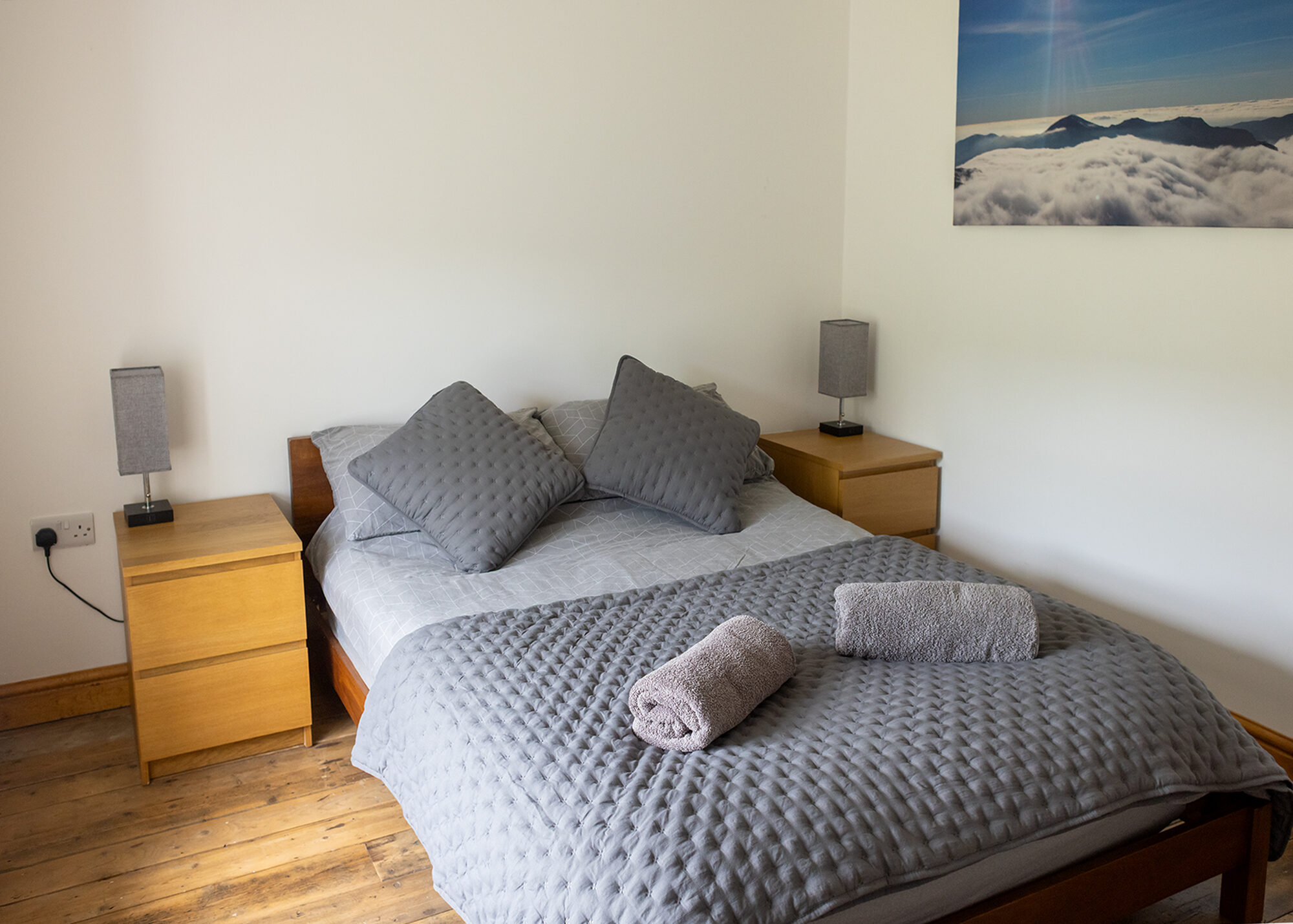 Bright double bedroom with grey throw