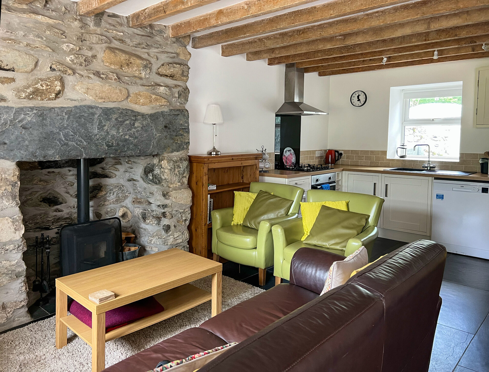 Cosy open plan lounge and kitchen with stone fireplace