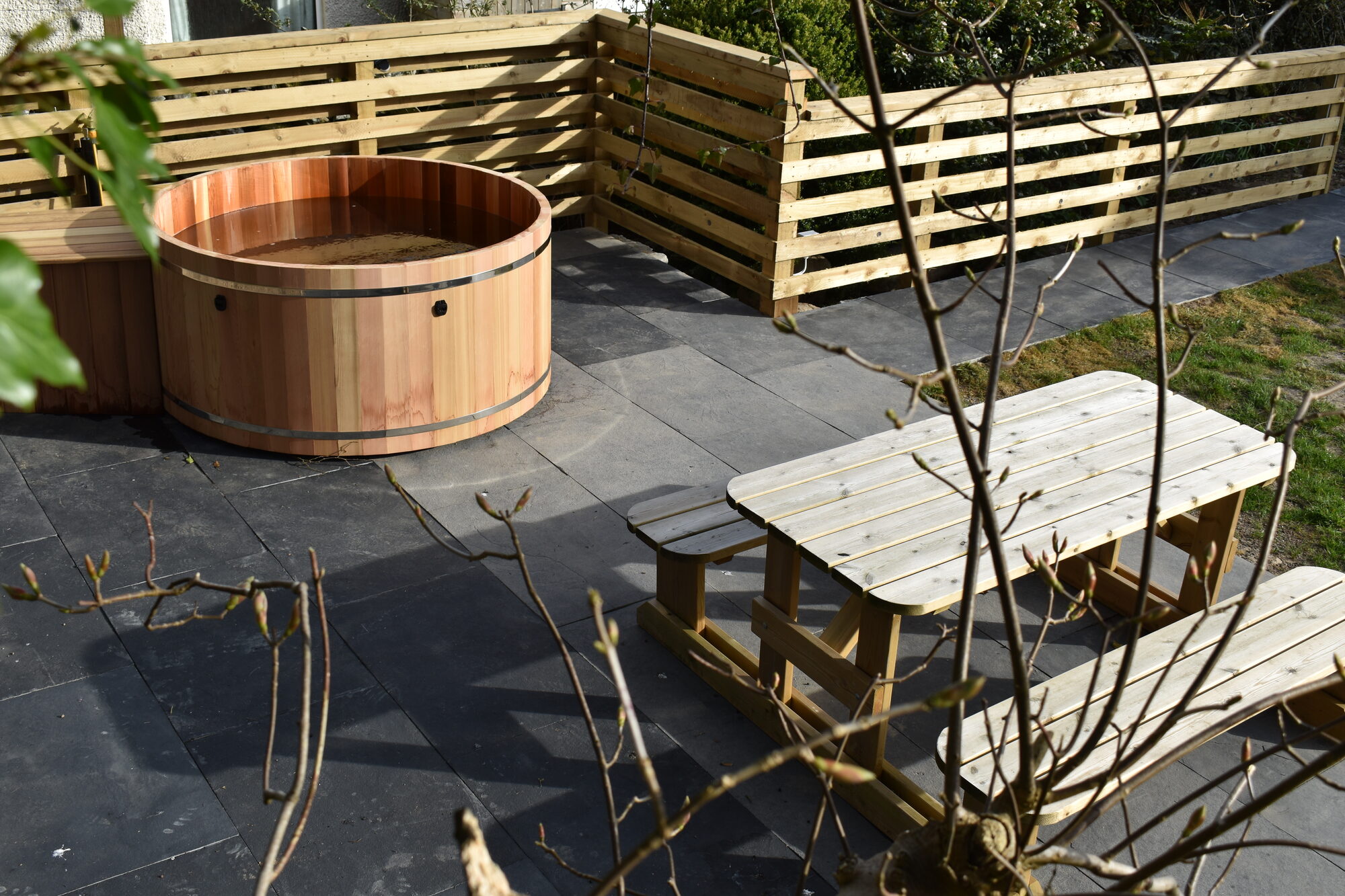 Wooden hot tub and picnic bench seating area